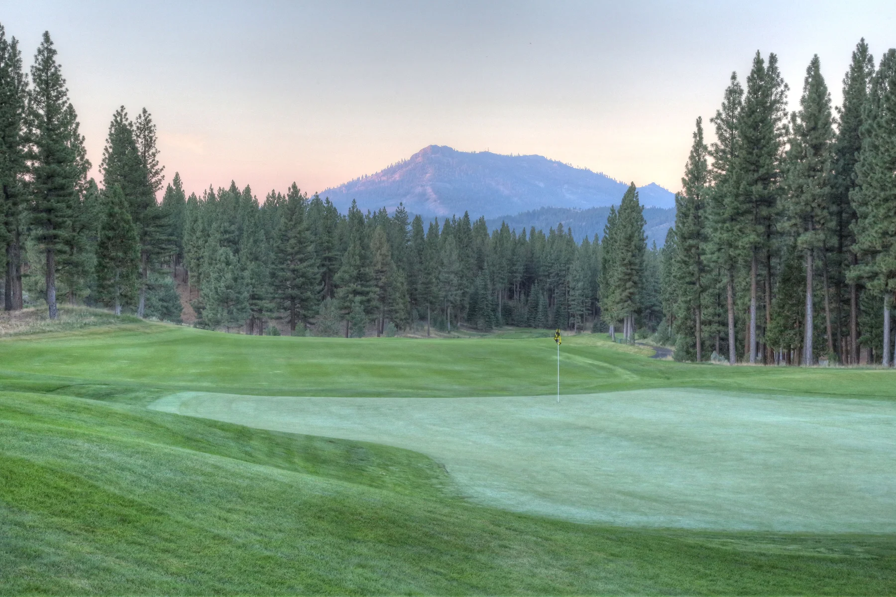 Grizzly Ranch Golf Club — green at dusk with mountain silhouette